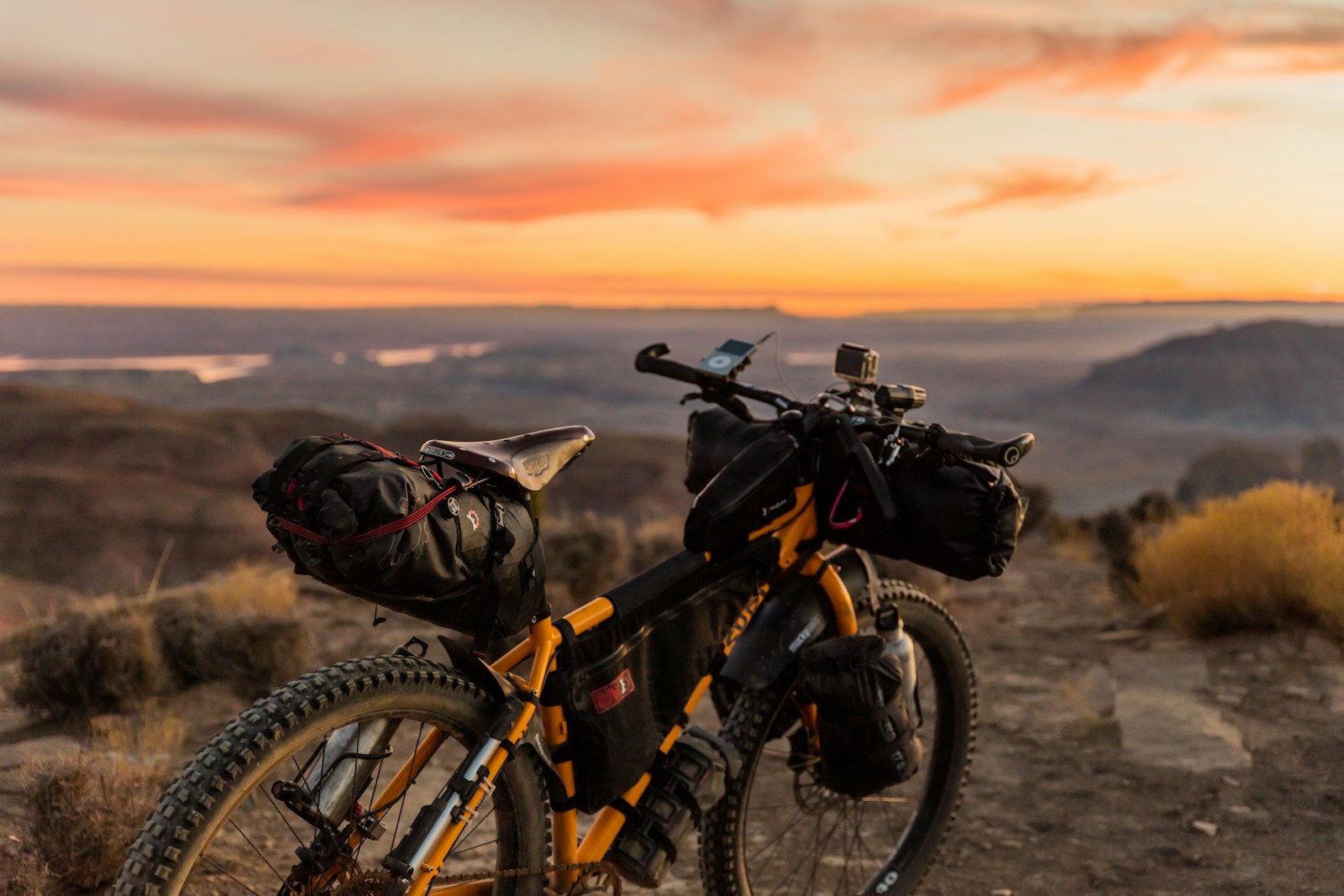 orange and black mountain biking on hill