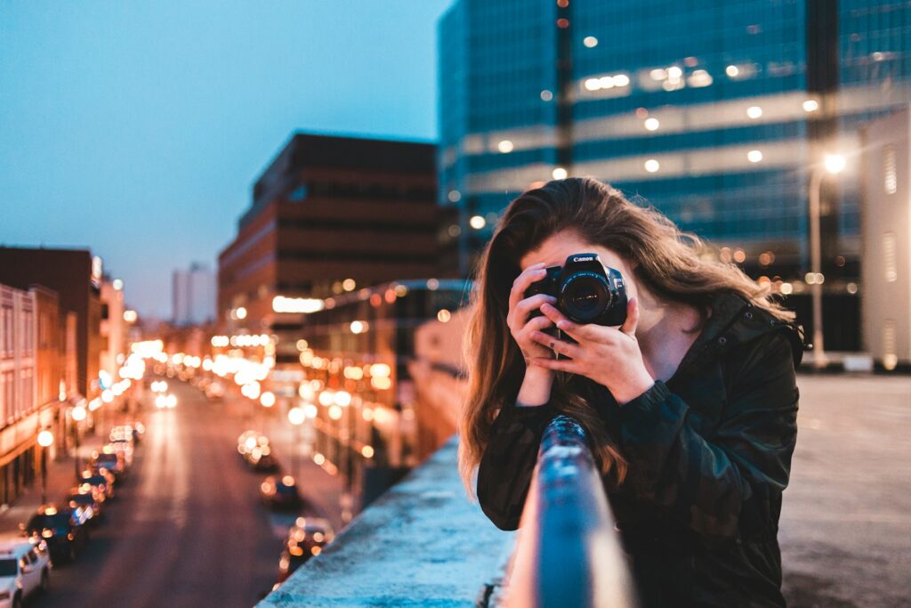 woman using black camera outdoors