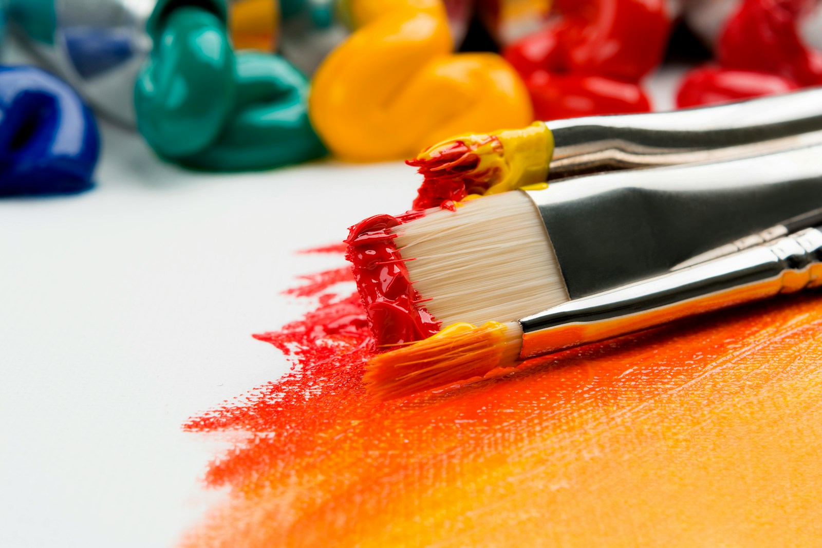 three silver paint brushes on white textile for painting