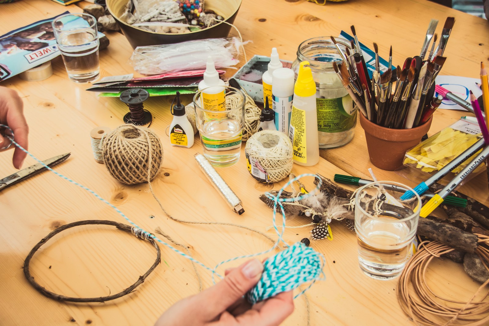 person holding blue and white tread for crafting